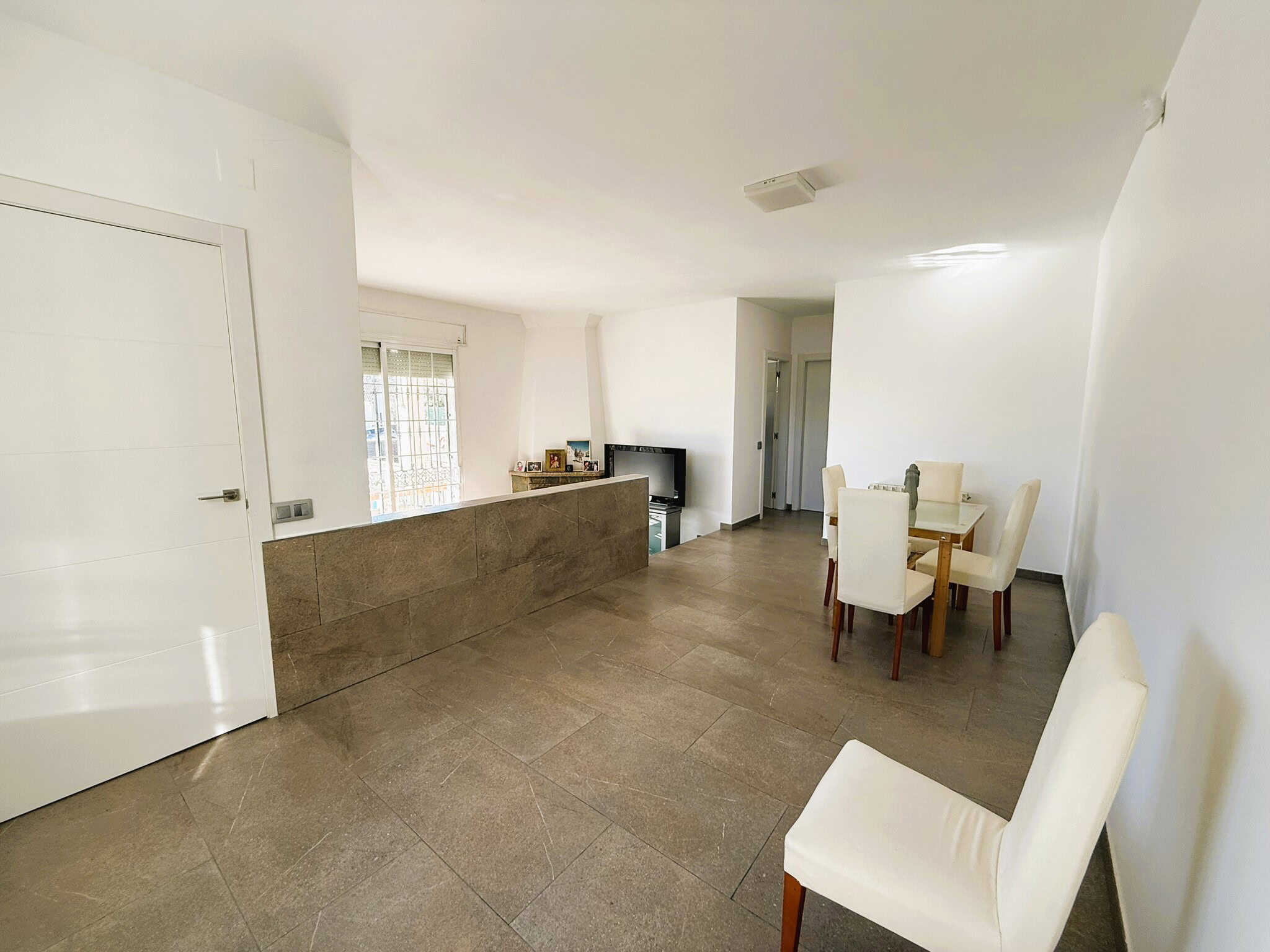 Habitat urbà amb sala d'estar menjador i finestres grans, decoració moderna i lluminosa, molt espai i funcionalitat, ideal per habitatge familiar o inversió immobiliària.