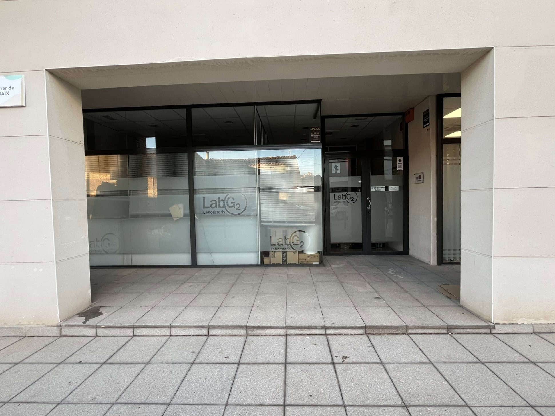 Entrada d'edifici amb vidre i logotip de LabG2, immobiliària i serveis jurídics amb finques, ubicada a Tarragona, amb façana moderna i accessible, ideal per a compra, venda i gestió immobiliària.