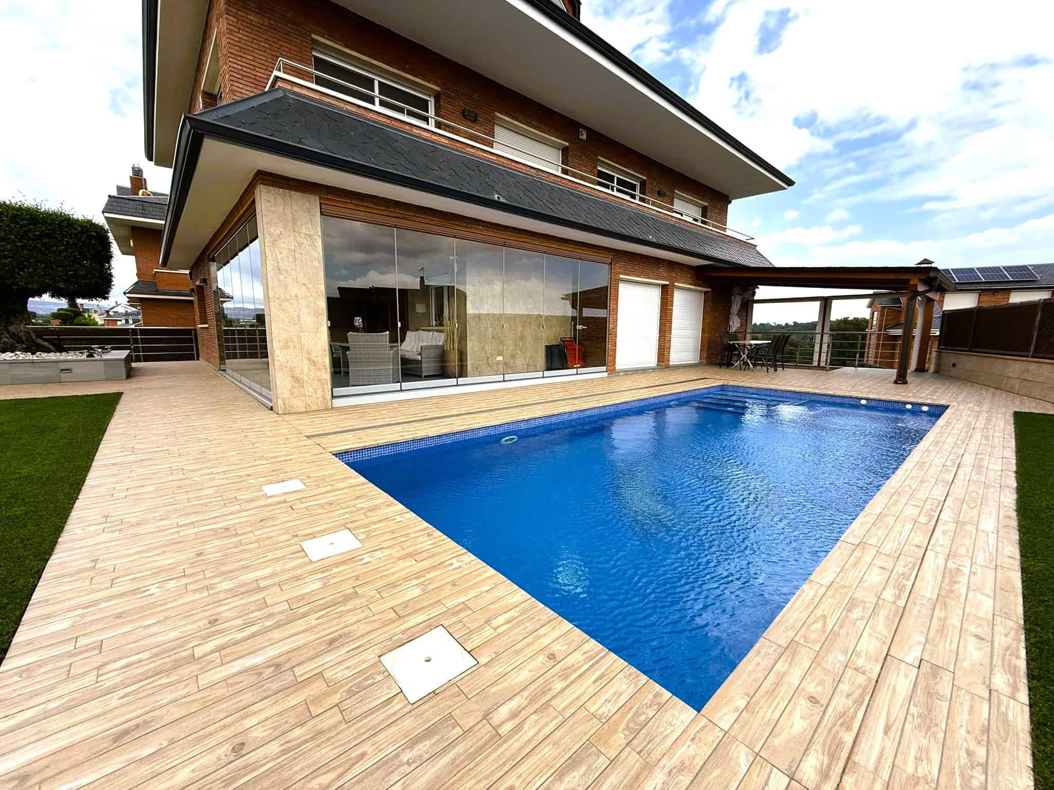 Escola de la imatge d'una casa moderna amb piscina a l'exterior, amb gran espai de terrassa i grans finestres, ideal per a serveis legals immobiliaris.