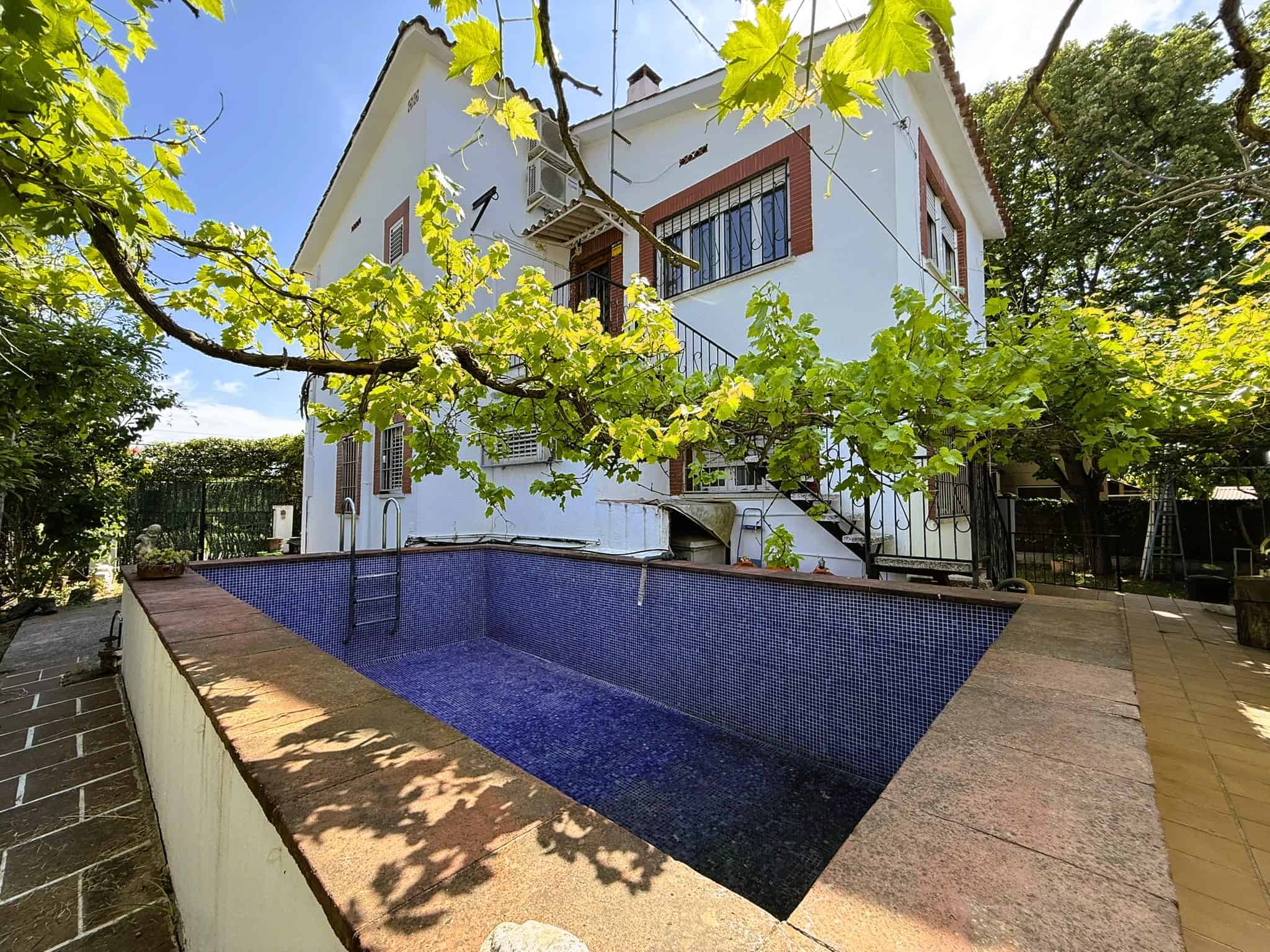 Piscina privada a la casa de campanya amb arbres i jardí, immoble amb possibilitats de compra, venda i gestió immobiliària a Catalunya.