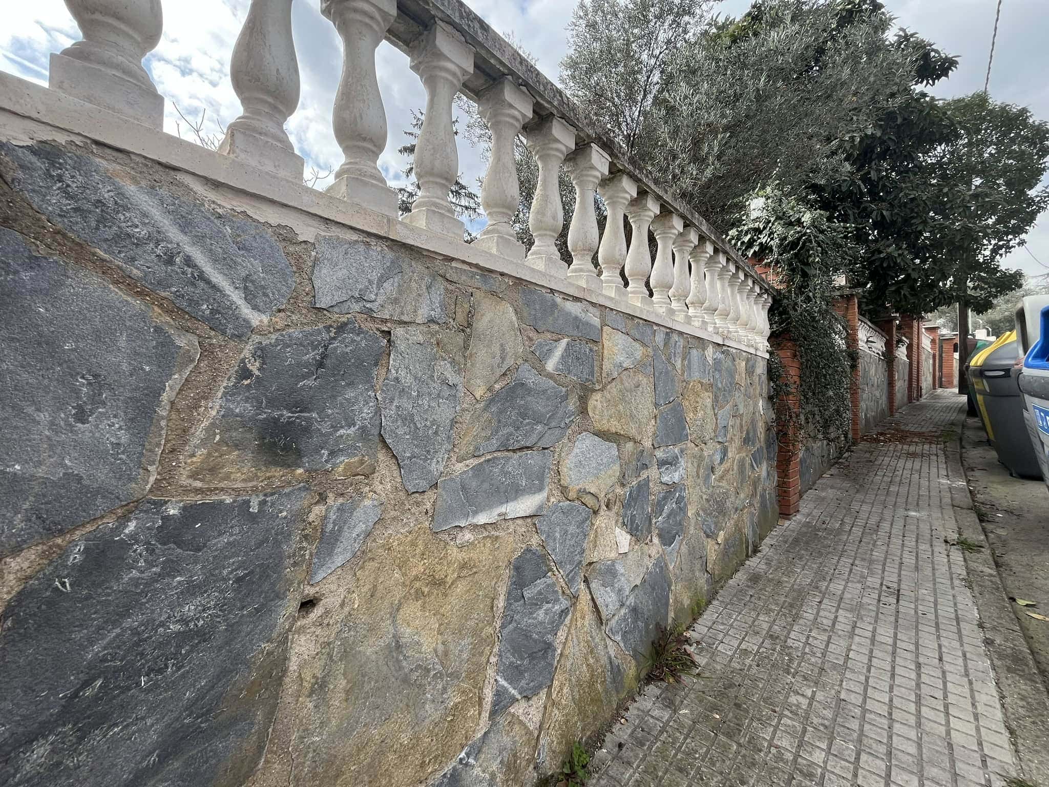 Parement de pedra natural i barana de balustres de ceramic a la finca.