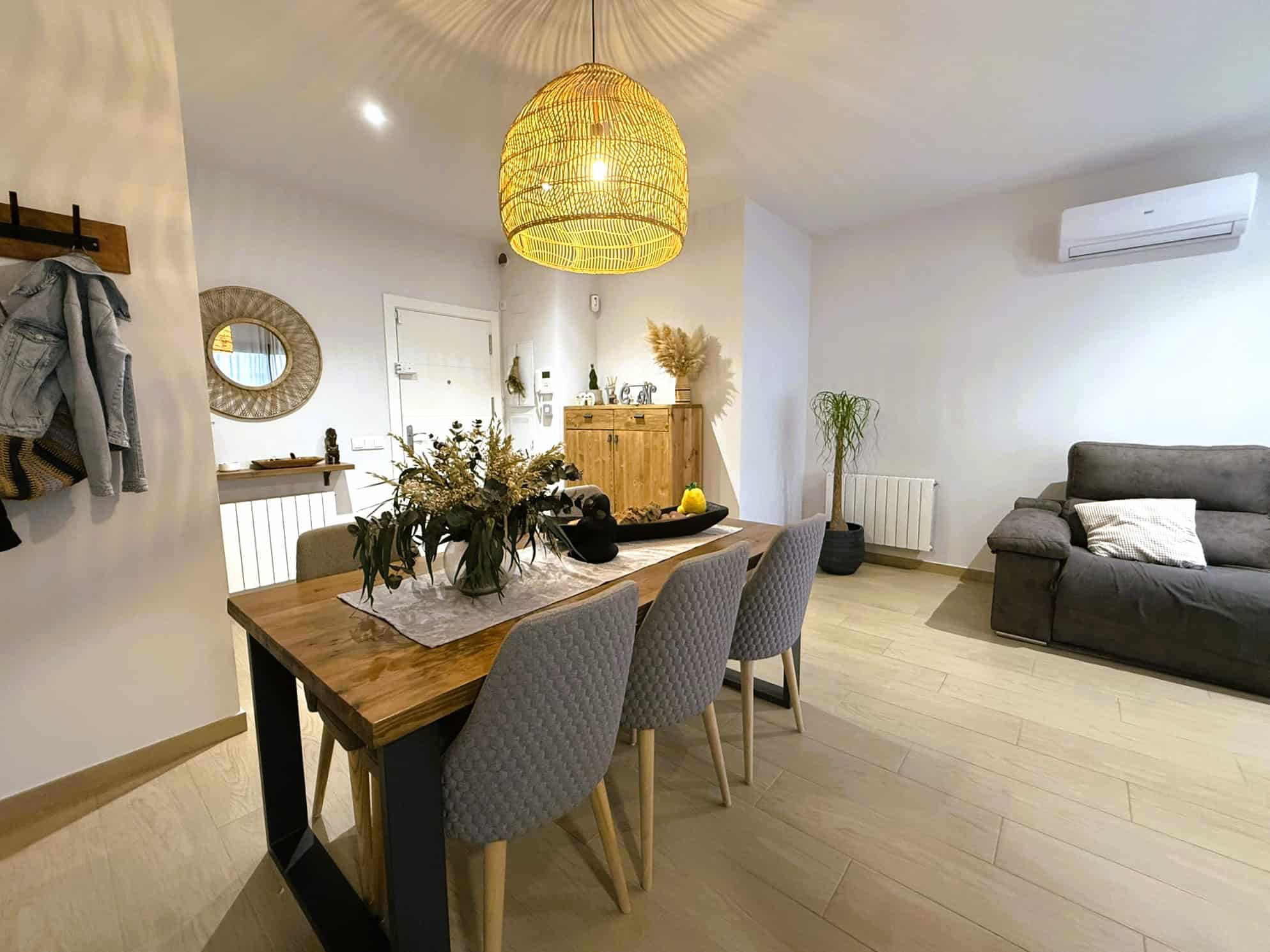 Suport imatge d'interior d'un menjador modern amb taula de fusta, cadires acolorides, decoració natural, llum càlida i espai lluminós, ideal per a serveis immobiliaris i advocats especialitzats en immobiliària a Torra Advocats.