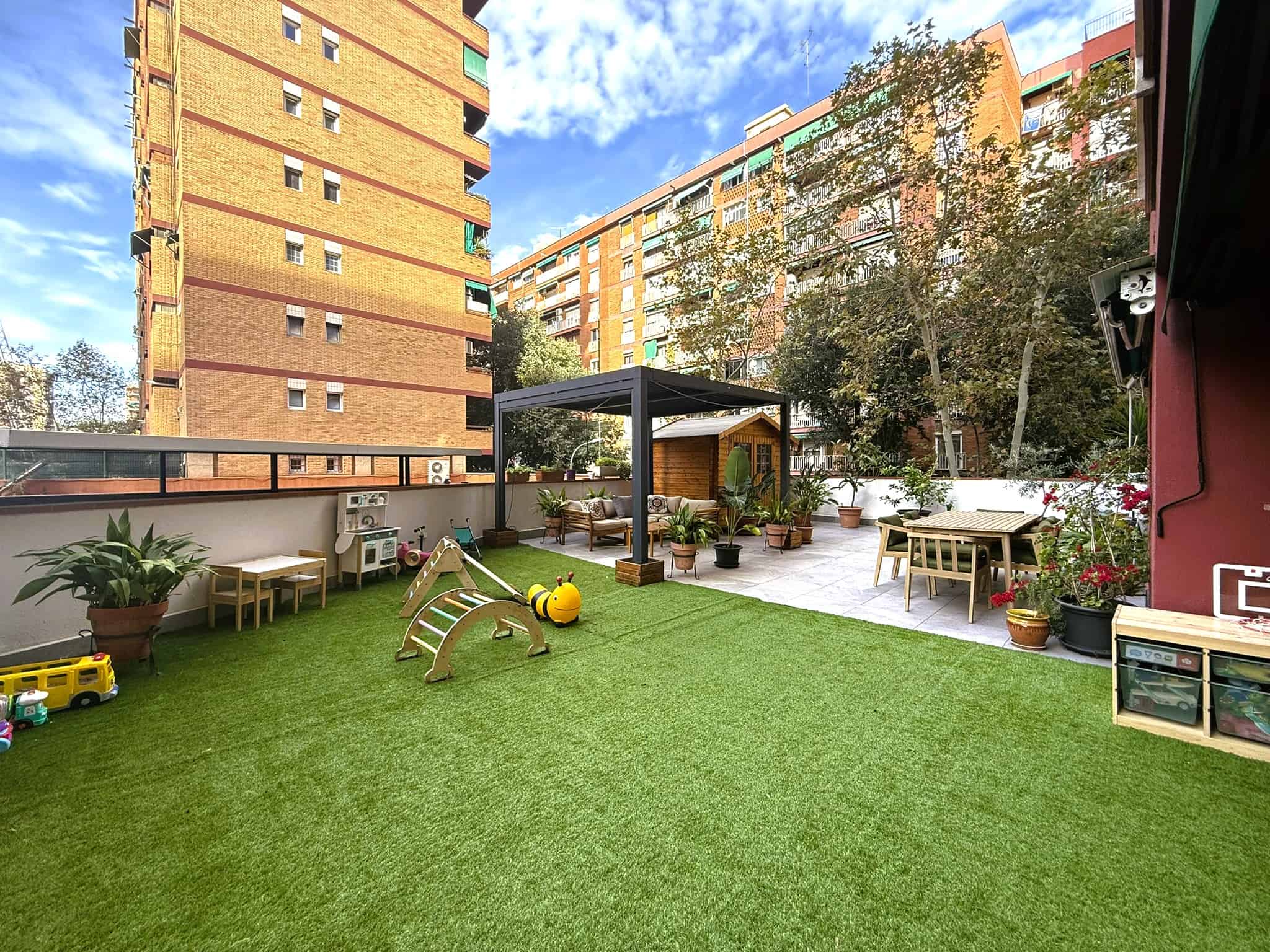 àtic amb jardí interior, zona infantil i espai per a terrassa en un edifici residencial modern a Barcelona.