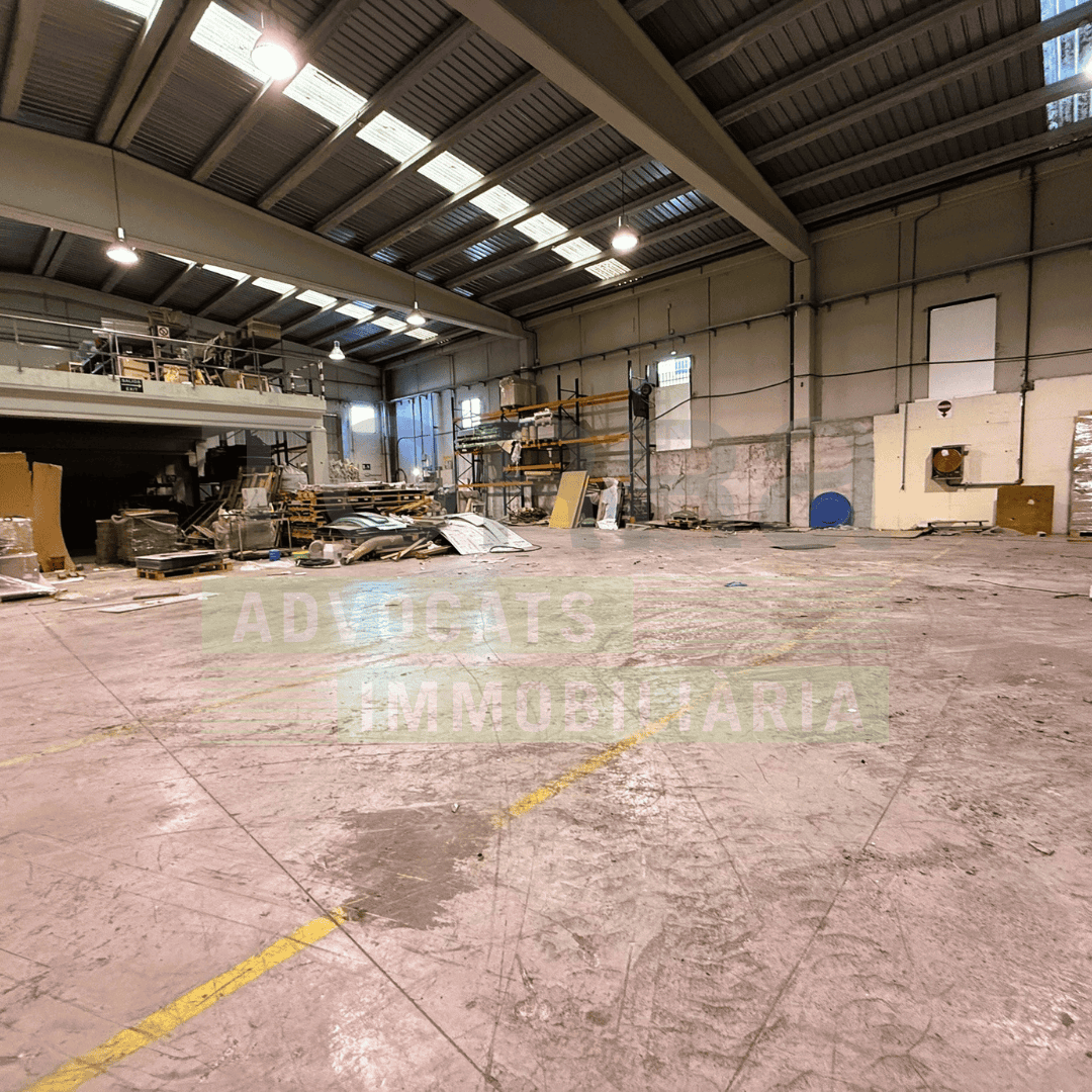 Interior d'un magatzem industrial a Polígon La Borda, amb espai ampli i estructura metàl·lica, ideal per lloguer de naus industrials a la zona.