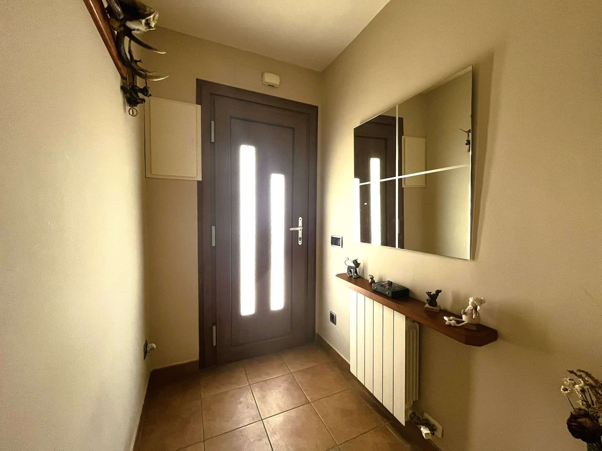 Entrada de casa independent a la zona del Castell de Palau-Solità i Plegamans amb porta moderna i mirall.