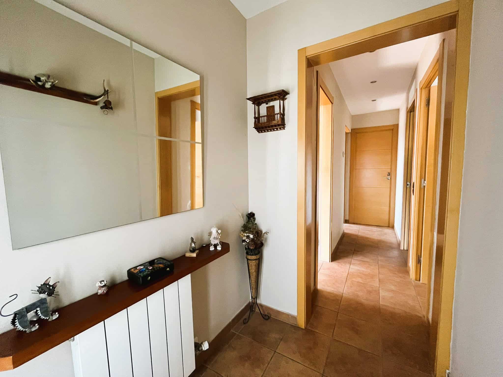 Interior de casa independent a Palau-Solità amb decoració acollidora i passadís ampli.